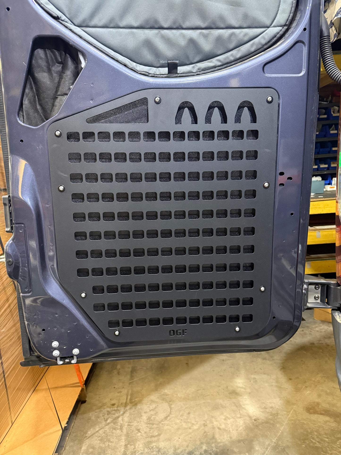 Black aluminum MOLLE panel installed on the lower rear door of a Mercedes Sprinter van
